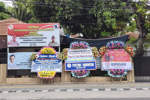 Sejumlah karangan bunga tampak di luar gang rumah Jokowi di Solo. Foto: Arfiansyah Panji Purnandaru/kumparan