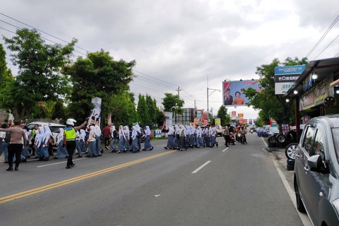 Anak sekolah hingga warga berjajar di jalan menyambut pulangnya Presiden ke-7 RI Jokowi ke Kota Solo, Minggu (20/10/2024). Foto: Arfiansyah Panji Purnandaru/kumparan