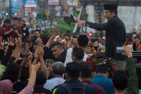 Presiden ke-7 Joko Widodo membagikan kaos ke warga saat melintas di jalan Colomadu, Karanganyar, Jawa Tengah, Minggu (20/10/2024). Foto: Aloysius Jarot Nugroho/ANTARA FOTO  