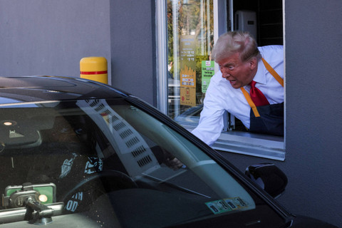 Calon presiden dari Partai Republik dan mantan Presiden AS Donald Trump bekerja di belakang meja kasir saat mengunjungi McDonalds di Feasterville-Trevose, Pennsylvania, Amerika Serikat, Minggu (20/10/2024). Foto: Doug Mills/Pool via REUTERS