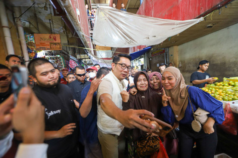 Calon Gubernur Jakarta nomor urut satu Ridwan Kamil berswafoto dengan pembeli saat blusukan di Pasar Kebayoran Lama, Jakarta, Kamis (24/10/2024). Foto: Iqbal Firdaus/kumparan