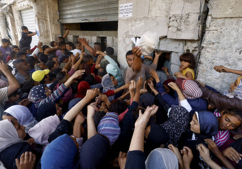 Warga antre membeli roti saat konflik Israel dan Hamas berlangsung di Khan Younis, Gaza, Rabu (23/10/2024). Foto: Mohammed Salem/REUTERS 