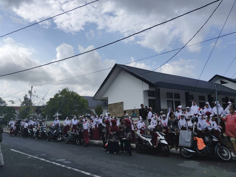 Siswa SD hingga SMA berjejer di sepanjang Jalan Jenderal Gatot Soebroto depan Akmil Magelang. Foto: Arfiansyah Panji Purnandaru/kumparan