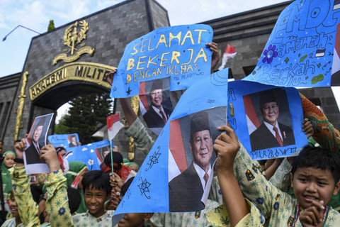 Sejumlah siswa membentangkan poster dan bendera Merah Putih saat akan menyambut kegiatan rapat kerja Presiden Prabowo Subianto dan Kabinet Merah Putih 2024-2029 di kawasan Akademi Militer (Akmil) Magelang, Jawa Tengah, Kamis (24/10/2024). Foto: Muhammad Adimaja/ANTARA FOTO