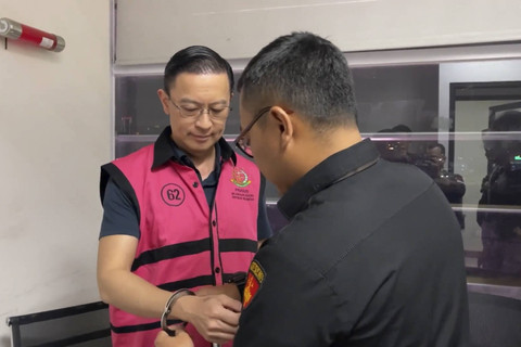 Petugas Kejaksaan memasangkan borgol dengan mengenakan rompi tahanan kepada Menteri Perdagangan periode 2015-2016 Thomas Lembong usai ditetapkan sebagai tersangka kasus dugaan korupsi impor gula oleh Kejaksaan Agung di Jakarta, Selasa (29/10/2024). Foto: Dok. Kejagung