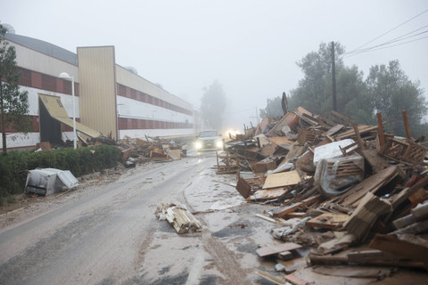 Mobil-mobil bergerak melewati barang-barang yang rusak dari sebuah pabrik mebel yang terkena dampak hujan lebat yang menyebabkan banjir di La Alcudia, wilayah Valencia, Spanyol, 30 Oktober 2024.  Foto: Jon Nazca/Reuters