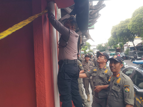 Polisi dan Satpol PP menyegel sebuah outlet penjual minuman keras di wilayah Kota Yogyakarta. Foto: Polresta Yogyakarta