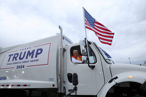 Calon presiden dari Partai Republik dan mantan Presiden AS Donald Trump duduk di dalam truk sampah sambil mengenakan rompi anti peluru, di landasan pacu Bandara Internasional Green Bay Austin Straubel di Green Bay, Wisconsin, AS, Rabu (31/10/2024). Foto: Brendan McDermid/REUTERS 