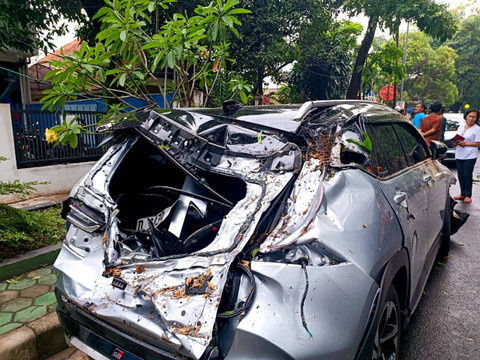 Mobil hancur akibat tertimpa pohon tumbang di Jalan Cisadea, Cibenying Kidul, Bandung saat hujan deras pada Jumat (1/11). Foto: Robby Bouceu/kumparan