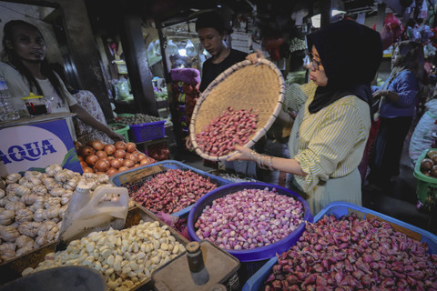 Pedagang memilah bawang merah di kiosnya di Pasar Senen, Jakarta, Jumat (1/11/2024). Foto: Jamal Ramadhan/kumparan