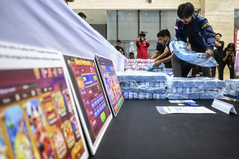 Petugas menata barang bukti berupa uang tunai pecahan rupiah saat konferensi pers pengungkapan kasus judi online di Bareskrim Mabes Polri, Jakarta, Sabtu (2/11/2024). Foto: Rivan Awal Lingga/ANTARA FOTO