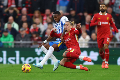 Kostas Tsimikas dari Liverpool berusaha merebut bola dari Pervis Estupinan dari Brighton & Hove di Liga Premier pada Anfield, Liverpool, Inggris, 2 November 2024. Foto: REUTERS/Molly Darlington