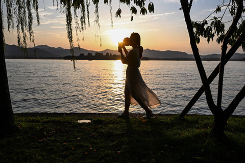 Ilustrasi perempuan berjalan di rumput. Foto: Hector RETAMAL / AFP
