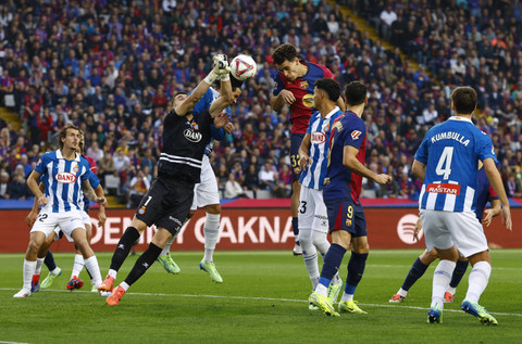 Pemain RCD Espanyol Joan Garcia beraksi dengan pemain FC Barcelona Hector Fort pada pertandingan LaLiga antara FC Barcelona melawan Espanyol di Estadi Olimpic Lluis Companys, Barcelona, Spanyol, Minggu (3/11/2024). Foto: Albert Gea/REUTERS 
