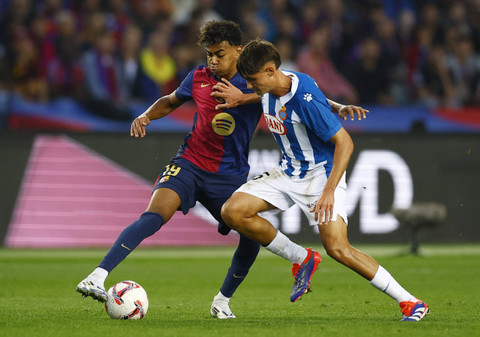 Lamine Yamal dari FC Barcelona beraksi dengan pemain RCD Espanyol Rafel Bauza pada pertandingan LaLiga antara FC Barcelona melawan Espanyol di Estadi Olimpic Lluis Companys, Barcelona, Spanyol, Minggu (3/11/2024). Foto: Albert Gea/REUTERS 