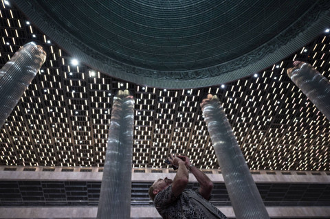 Seorang peserta Forum Internasional Humanitarian Islam memotret kubah dalam masjid saat berkunjung di Masjid Istiqlal, Jakarta, Senin (4/11/2024). Foto: Aprillio Akbar/ANTARA FOTO