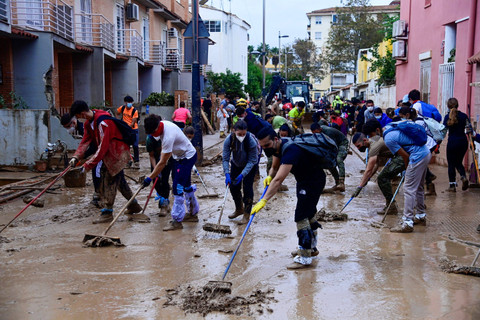 Anggota militer dan relawan membersihkan lumpur dan puing-puing akibat banjir di Alfafar, Valencia, Spanyol, Senin (4/11/2024).  Foto: JOSE JORDAN / AFP