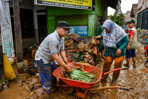 Warga menyelamatkan pakaian pascabanjir bandang di Banjaran Wetan, Kabupaten Bandung, Jawa Barat, Rabu (6/11/2024). Foto: Raisan Al Farisi/ANTARA FOTO