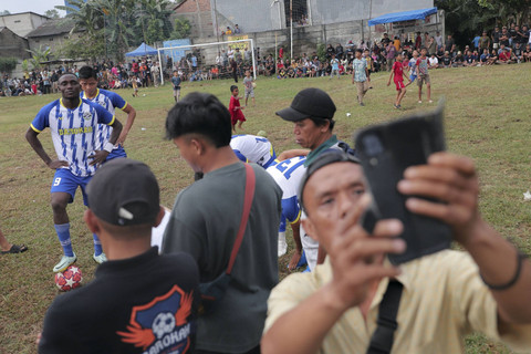Salah satu penonton melakukan swafoto bersama pemain tarkam. Foto: Iqbal Firdaus/kumparan