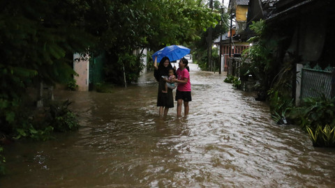 Dua warga berjalan melewati banjir di perumahan Bukit Pamulang Indah, Pamulang, Tangerang Selatan, Banten, Senin (11/11/2024). Foto: ANTARA FOTO/Alif Bintang