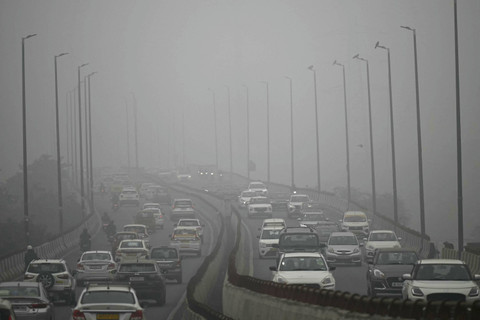 Sejumlah kendaraan berada di jalanan di tengah kabut asap yang pekat di New Delhi, India, Rabu (13/11/2024). Foto: SAJJAD HUSSAIN/AFP