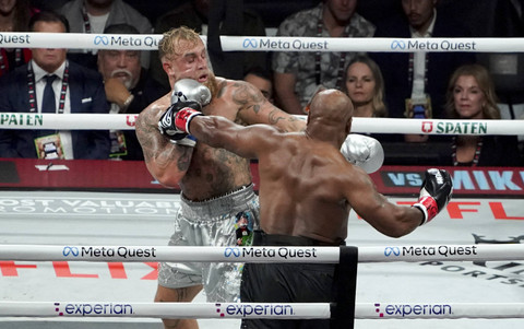 Petinju senior Mike Tyson melakukan pukulan jeep kepada Youtuber sekaligus petijnju Jake Paul melakukan dalam pertandingan tinju kelas berat di Texas, Amerika Serikat, Jumat (15/11/2024). Foto: Timothy A. Clary/AFP