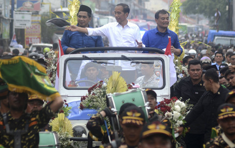 Presiden ke-7 Indonesia Jokowi didampingi Calon Gubernur dan Calon Wakil Gubernur Jawa Tengah Ahmad Luthfi- Taj Yasin membagikan kaos dari mobi Jip saat pawai di Jalan Raya Tegal-Purwokerto, Kabupaten Tegal, Jawa Tengah, Sabtu (16/11/2024). Foto: Oky Lukmansyah/Antara Foto