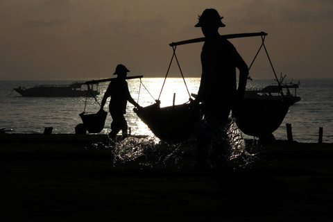 Petani menyiram air laut ke lahan pembuatan garam di Pantai Kusamba, Klungkung, Bali. Foto: Nyoman Hendra Wibowo/ANTARA FOTO