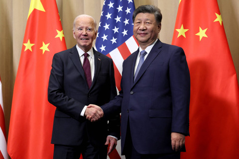 Presiden AS Joe Biden berjabat tangan dengan Presiden China Xi Jinping di sela-sela KTT APEC di Lima, Peru, Sabtu (16/11/2024). Foto: Leah Millis / POOL / AFP