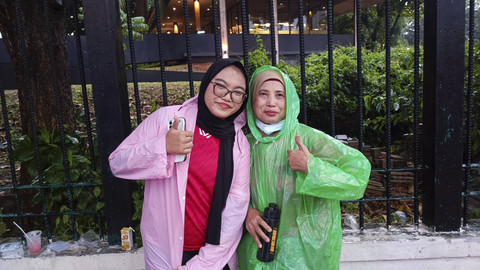 Ibu dan anak asal Tanjung Priok tak goyah atas jarak dan hujan yang menghalangi mereka untuk nonton Indonesia vs Arab Saudi di SUGBK, Jakpus, Selasa (19/11/2024). Foto: Thomas Bosco/kumparan