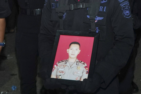 Seorang anggota kepolisian membawa bingkai foto Kasat Reskrim Polres Solok Selatan AKP Ryanto Ulil Anshar saat tiba di rumah duka, Makassar, Sulawesi Selatan, Sabtu (23/11/2024) dini hari. Foto: Hasrul Said/ANTARA FOTO