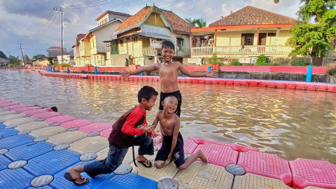 Tiga orang Anak-anak yang asyik berpose sesuai mandi di sungai yang menjdi aktivitas baru kala musim hujan di Palembang, Sabtu (23/11) Foto: ary priyanto/urban id