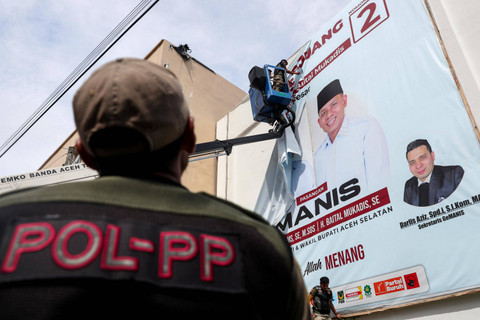 Petugas Satpol PP membongkar alat peraga kampanye Pilkada 2024 di Banda Aceh, Aceh, Minggu (24/11/2024).  Foto: Irwansyah Putra/ANTARA FOTO