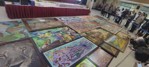 Tumpukan uang tunai dan lukisan yang disita polisi terkait kasus judi online yang melibatkan pegawai Komdigi. Foto: Rachmadi Rasyad/kumparan