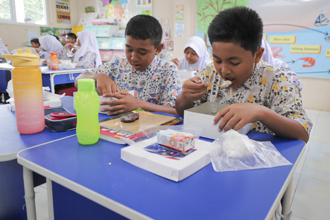 Sejumlah siswa menyantap makanan saat simulasi program Makan Siang Bergizi Gratis di sekolah wilayah Lanud Halim Perdanakusuma di SDS Angkasa 5 Lanud Halim Perdanakusuma, Jakarta, Selasa (26/11/2024). Foto: Iqbal Firdaus/kumparan