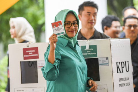 Calon Gubernur Banten Airin Rachmi Diany bersiap memasukkan kertas suara ke kotak suara saat menggunakan hak pilihnya di TPS 15 Sutera Narada, Alam Sutera, Tangerang Selatan, Banten, Rabu (27/11/2024). Foto: Galih Pradipta/ANTARA FOTO