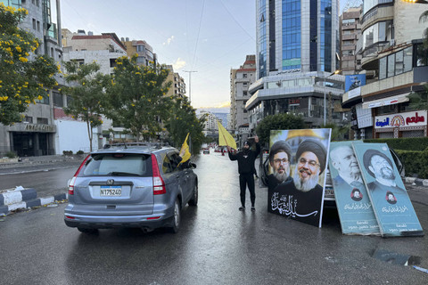 Kendaraan melambaikan bendera Hizbullah saat mereka berparade di pinggiran selatan Beirut pada 27 November 2024. Foto: AFP