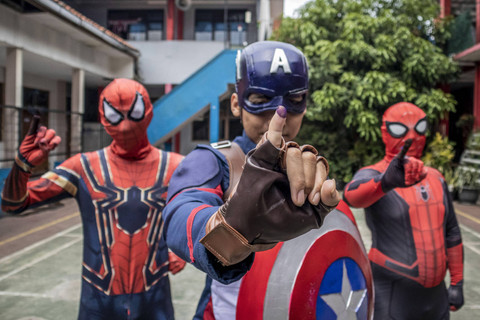 Petugas berkostum Superhero menunjukkan jari kelingking yang telah dicelupkan tinta usai menggunakan hak suaranya saat Pilkada 2024 di TPS 12 Pasir Kaliki, Kota Cimahi, Jawa Barat, Rabu (27/11/2024). Foto: Abdan Syakura/ANTARA FOTO