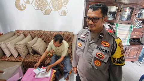 Angota Polsek Plaju yang mendampingi seorang warga saat melakukan pencoblosan surat suara dalam proses pilkada di Palembang, Rabu (27/11) Foto: ary priyanto/urban id