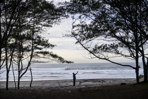 Wisatawan berfoto di kawasan wisata Pantai Cemara Cipanglay, Kecamatan Cidaun, Kabupaten Cianjur, Jawa Barat, Sabtu (30/11/2024). Foto: Raisan Al Farisi/ANTARA FOTO