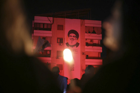 Potret mendiang pemimpin Hizbullah Hassan Nasrallah diletakkan di sebuah bangunan selama peringatan di lokasi di mana ia terbunuh dalam serangan udara Israel, di lingkungan Haret Hreik, pinggiran selatan Beirut, Lebanon, Sabtu (30/11/2024). Foto: Ibrahim AMRO/AFP