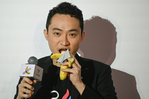 Pendiri kripto asal China Justin Sun memakan karya seni pisang berjudul "Comedian" karya Maurizio Cattelan di Hong Kong, Jumat (29/11/2024). Foto: PETER PARKS / AFP