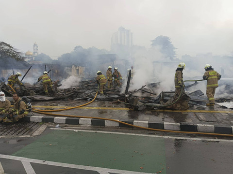 Petugas melakukan pendinginan usai kebakaran melanda bangunan semi permanen di Jalan Salemba Raya, Jakarta Pusat, Senin (2/12/2024). Foto: X/ @humasjakfire