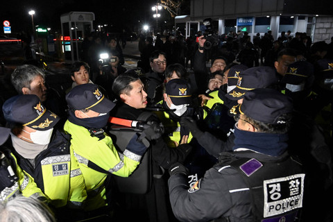 Polisi berjaga setelah Presiden Korea Selatan Yoon Suk Yeol mengumumkan darurat militer di depan gerbang utama Majelis Nasional di Seoul, Korea Selatan, Selasa (3/12/2024). Foto: JUNG YEON-JE / AFP