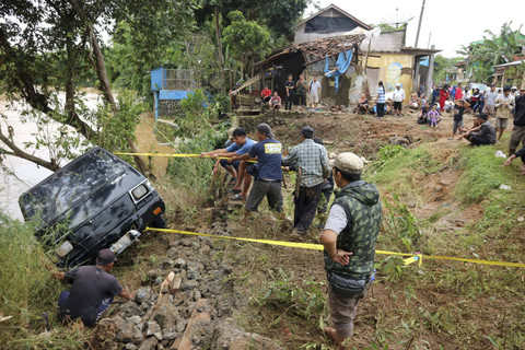 Sejumlah warga berusaha menarik mobil yang terbawa banjir bandang di Kampung Parungseah, Desa Curug Luhur, Sagaranten, Kabupaten Sukabumi, Jawa Barat, Kamis (5/12/2024). Foto: Iman/ANTARA FOTO