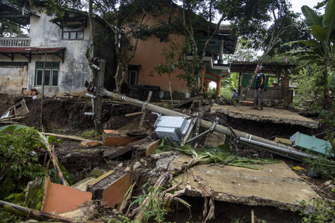 Relawan melihat akses jalan rusak terdampak bencana pergerakan tanah di Kadupandak, Kabupaten Cianjur, Jawa Barat, Jumat (6/12/2024). Foto: Novrian Arbi/ANTARA FOTO