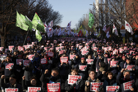 Sejumlah pengunjuk rasa membentangkan poster saat mengikuti aksi  pemakzulan Presiden Korea Selatan Yoon Suk Yeol, yang mengumumkan darurat militer di Seoul, Korea Selatan, Sabtu (7/12/2024).  Foto: Kim Hong-Ji/REUTERS