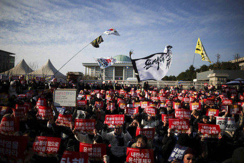 Sejumlah pengunjuk rasa membentangkan poster saat mengikuti aksi  pemakzulan Presiden Korea Selatan Yoon Suk Yeol, yang mengumumkan darurat militer di depan Majelis Nasional, Seoul, Korea Selatan, Sabtu (7/12/2024).  Foto: Kim Hong-Ji/REUTERS