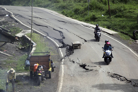 Pengendara motor melewati jalan retak dan amblas di Jalan Raya Baros-Sigaranten, Kabupaten Sukabumi, Jawa Barat, Minggu (8/12/2024). Foto: Yulius Satria Wijaya/ANTARA FOTO