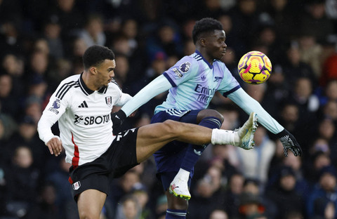 Antonee Robinson dari Fulham beraksi dengan Bukayo Saka dari Arsenal pada pertandingan Liga Inggris antara Fulham melawan Arsenal di Craven Cottage, London, Inggris, Minggu (8/12/2024). Foto: Peter Cziborra/REUTERS